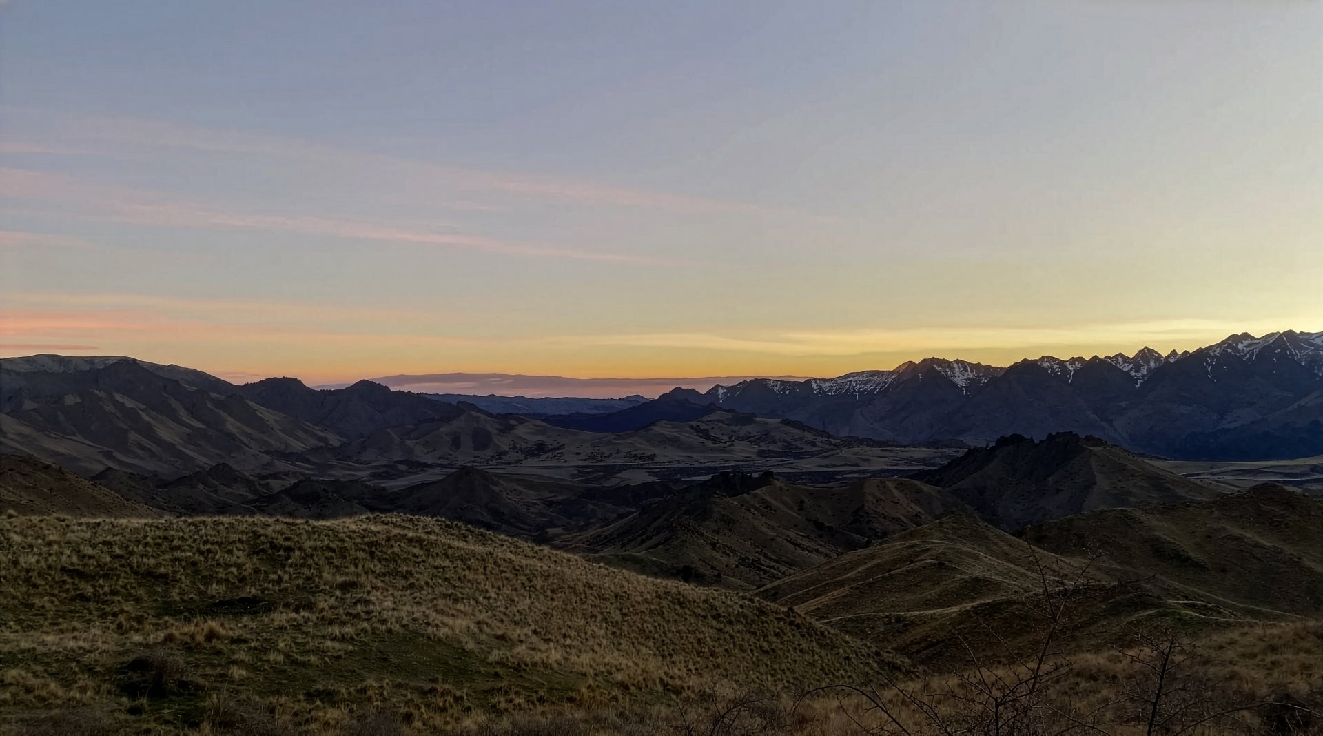 Vast mountain landscape at golden hour with bold WOKE FARMING overlay